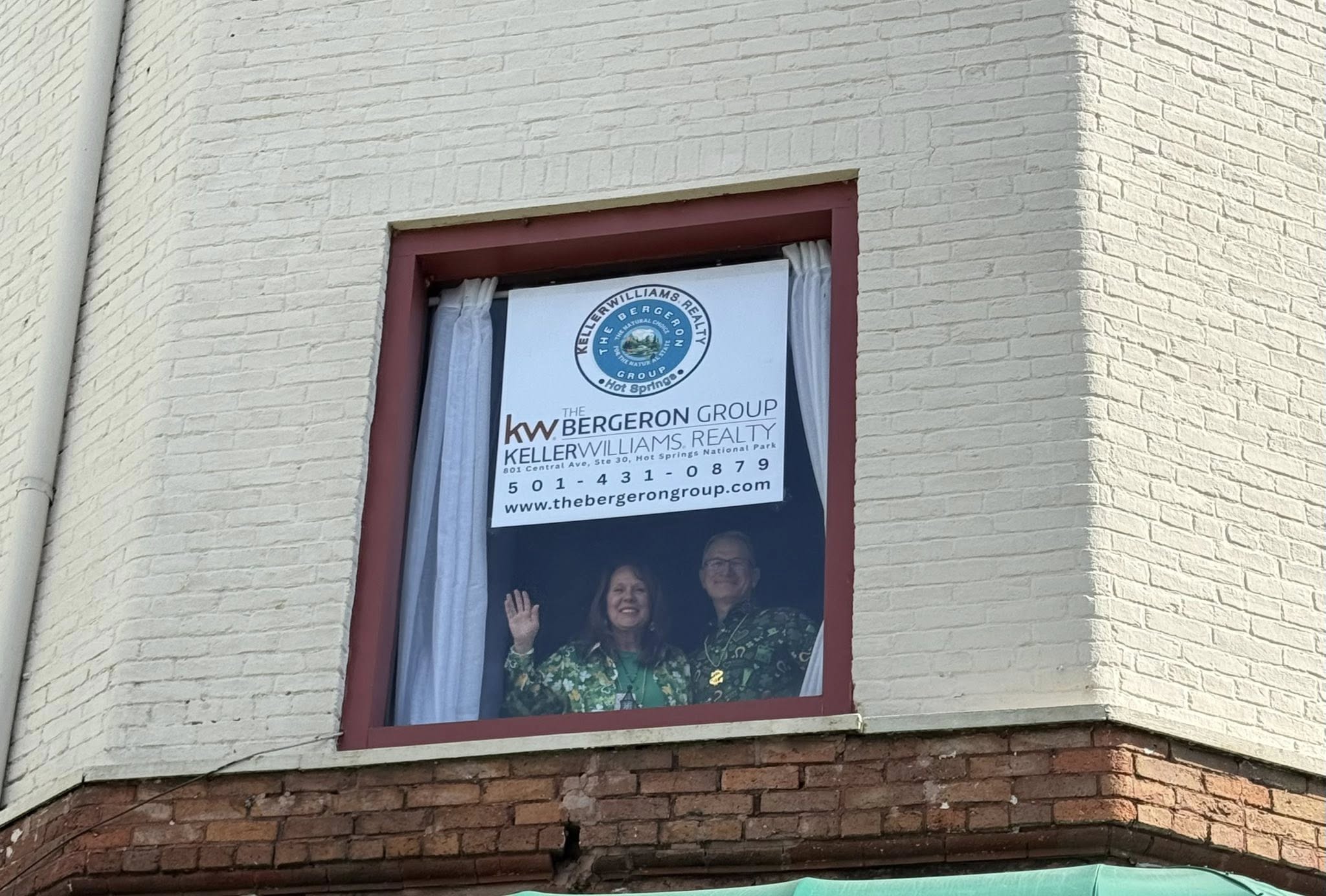 Nancy and Mark Bergeron waving from the Bergeron Group office window